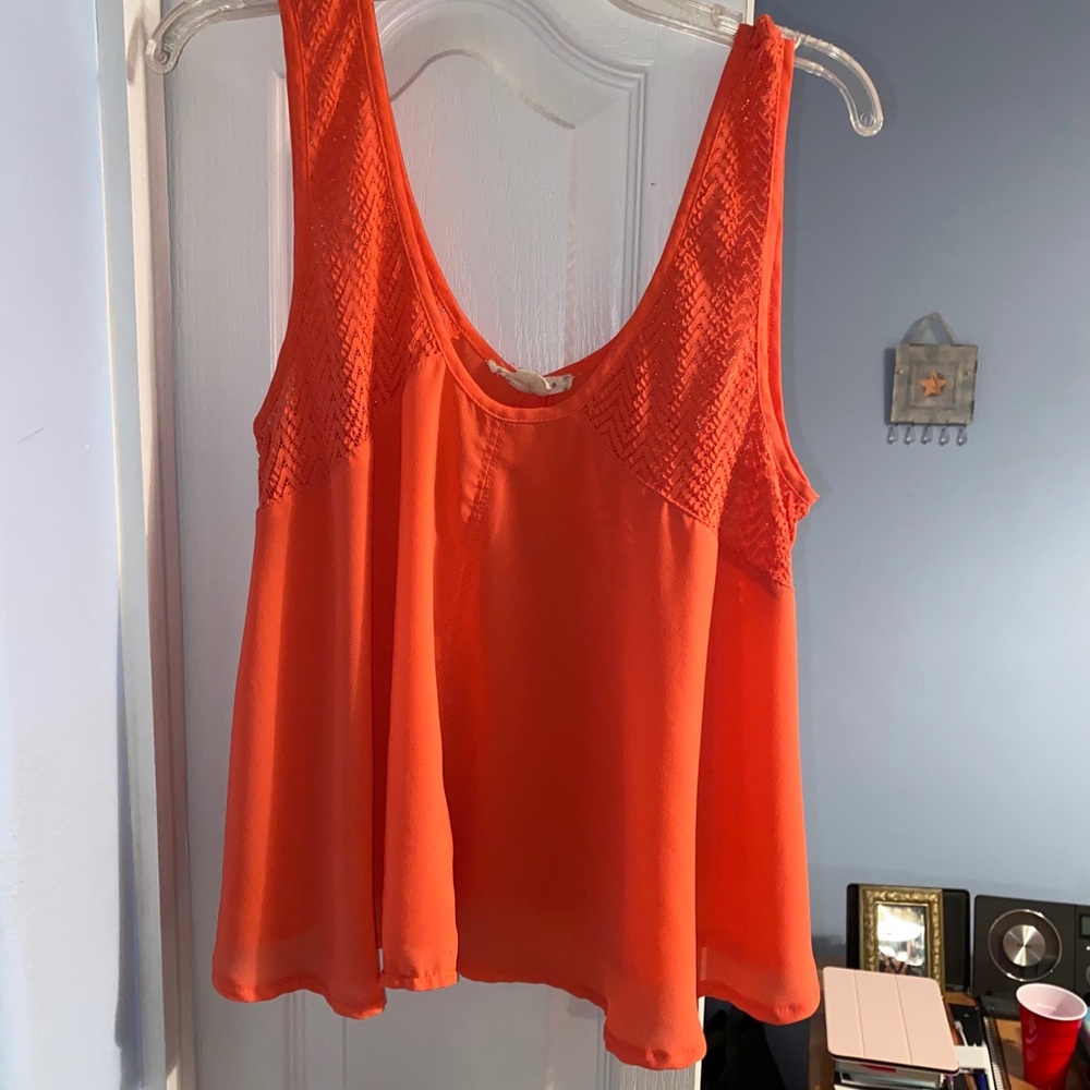 Coral sleeveless top with patterned detail.